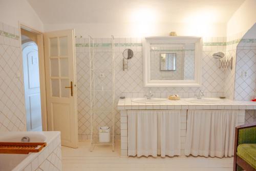 a bathroom with two sinks and a mirror at Family Hotel Okoř in Okoř