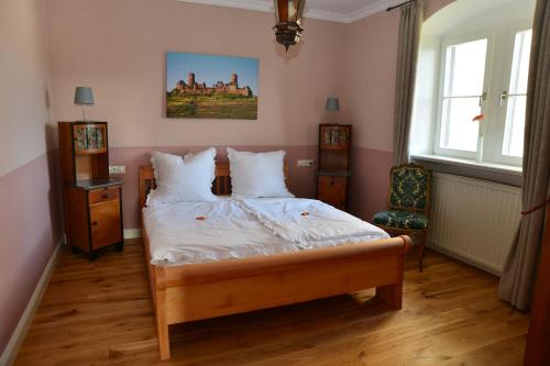 a bedroom with a bed with white sheets and pillows at Gästehaus auf der Burg im Vulkan Park Laacher See in Andernach