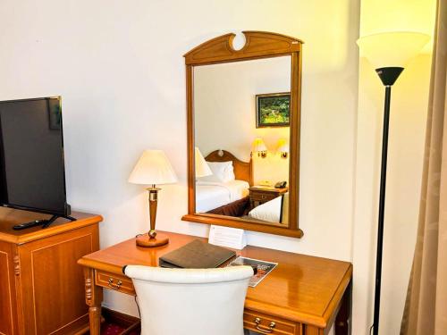 a hotel room with a desk and a mirror at Mulia Hotel in Bandar Seri Begawan