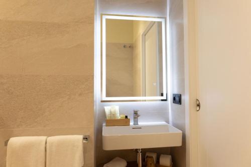 a bathroom with a white sink and a mirror at Pardavila 57 Slow Hotel in Marín
