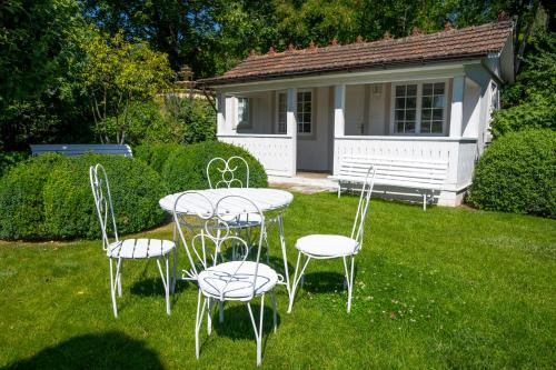 a table and chairs in a yard with a house at Family Hotel Okoř in Okoř