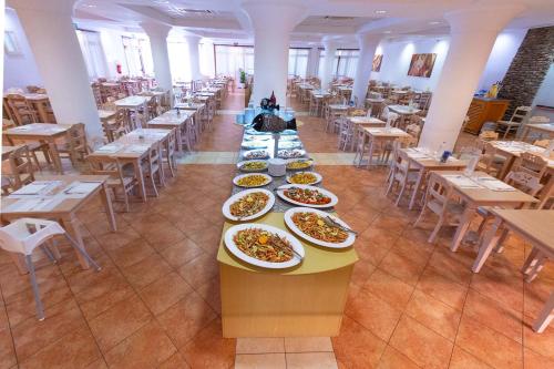 a row of plates of food on a table in a restaurant at Hotel La Caletta Village in La Caletta