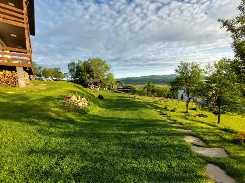a grassy field next to a house with a path at ZEN Apartments in Măgura