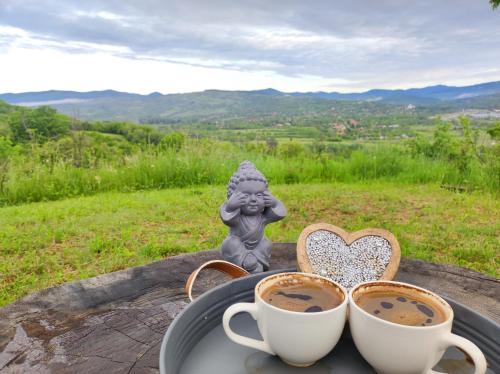 a tray with two cups of coffee and a statue at ZEN Apartments in Măgura