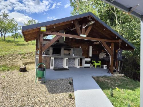 a pavilion with a table and a green chair at ZEN Apartments in Măgura