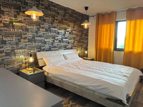 a bedroom with a bed and a wall covered in graffiti at ZEN Apartments in Măgura