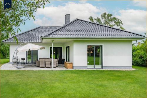 a small white house with a green lawn at Ferienhaus Zirchow 4 in Zirchow