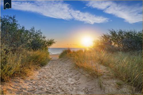 a path to the beach with the sunset in the background at Ferienhaus Zirchow 4 in Zirchow