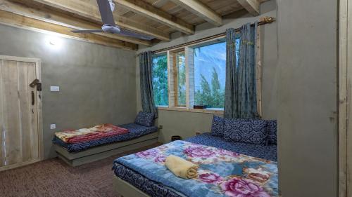 a bedroom with two beds and a window at ANCIENT STAY by MANOKUR- E- BASA in Minapin