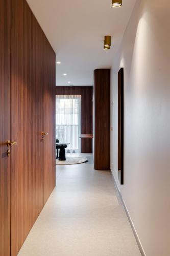 a hallway with wooden doors and a table in a room at Core Luxembourg -Studio Parking -50 Cents in Luxembourg