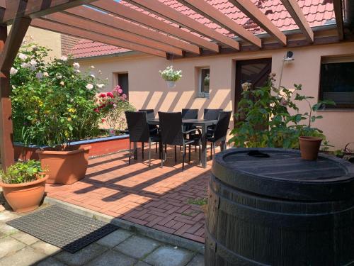 a patio with a table and chairs under a pergola at Willma Ferienhaus in Altdöbern