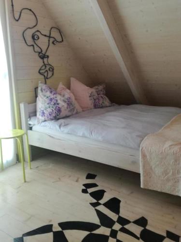 a bed with pillows on it in a room at Agroturystyka u Karoliny in Sarbinowo