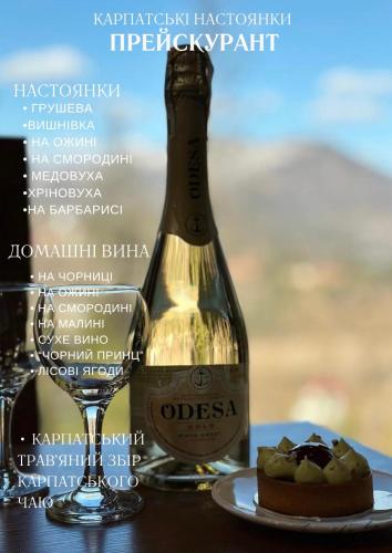 a bottle of wine and a piece of cake on a table at Love's Mount Resort in Slavske