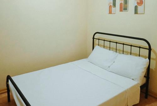 a bed with a black frame and a white pillow at RedDoorz at Yssa Ademar near Robinsons Jaro in Iloilo City