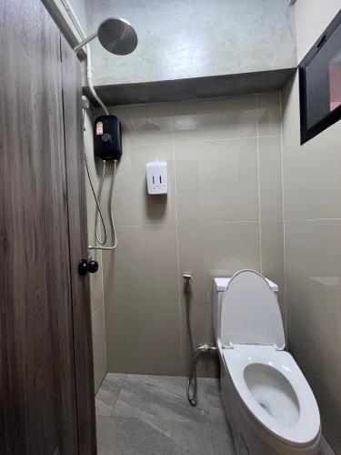 a bathroom with a toilet with a light on the wall at Apartment near Khlong Bang Luang in Bangkok