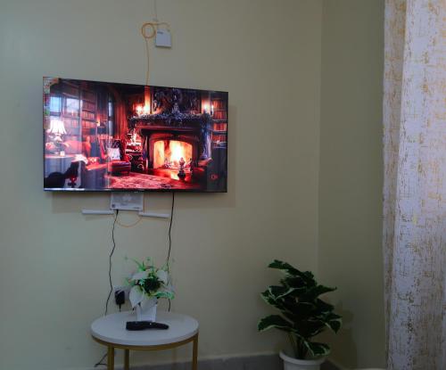 TV colgada en una pared con chimenea en Mareva Homes 1bedroom Thika town Ample parking wifi fridge microwave and all kitchen appliances, en Thika