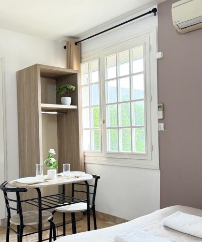 une pièce avec une table, des chaises et une fenêtre dans l'établissement Studio Platanes 3 - Proche Disneyland - Parking gratuit - Meaux, à Meaux