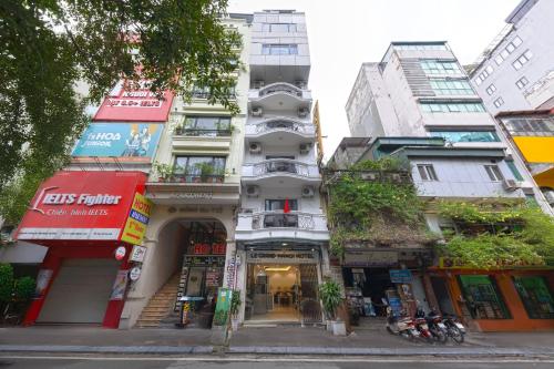 a tall white building on a city street at Dancenter Near Hoan Kiem Lake, Old Quarter formerly Le Grand The Tryst in Hanoi