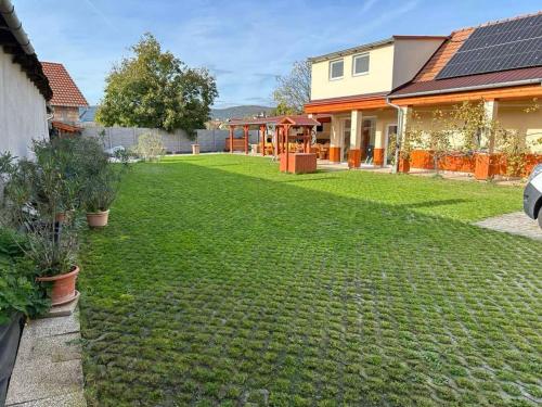 a yard with green grass and a house at Tündérrózsa Vendégház Pásztó in Pásztó