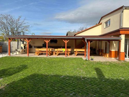 a pavilion with a table and chairs in a yard at Tündérrózsa Vendégház Pásztó in Pásztó