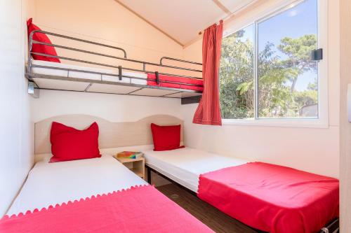 two beds in a small room with a window at Camping Village Poljana in Mali Lošinj