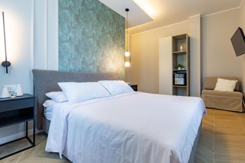 a bedroom with a large white bed and a chair at Como Lake Mastersuites in Cantù