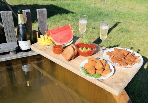 a table with plates of food and a bottle of wine at Aadniel's Holiday Village in Aula