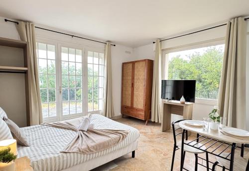 una camera da letto con un letto, un tavolo e una TV di Studio Platanes 2 - Proche Disneyland - Parking Gratuit - Meaux a Meaux