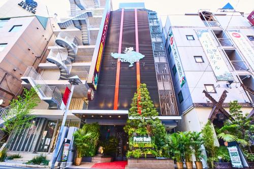 a building with a christmas tree in front of it at Petit Bali Ikebukuro in Tokyo