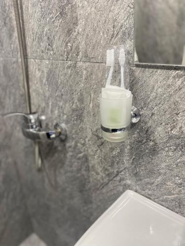 PʼarakʼarにあるErevan palas Apartamentの浴室の洗面台の横にあるカップに入った歯ブラシ