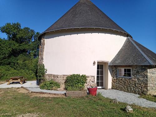 a large white building with a pointed roof at Domaine La Synchronicité - Gîte et Chambres d'Hôtes in Vaudrimesnil