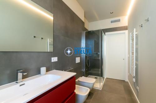 a bathroom with a white sink and a toilet at Condominio Vittoria in Lido di Jesolo