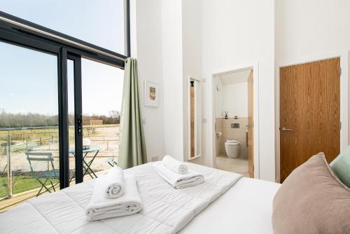 a bedroom with a bed and a large window at Sunday Sun BR31 Silverlake Dorset in Warmwell