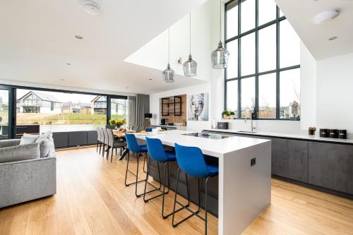 une cuisine et un salon avec un grand îlot avec des chaises bleues dans l'établissement Robins Retreat Silverlake OI19 Silverlake Dorset, à Warmwell