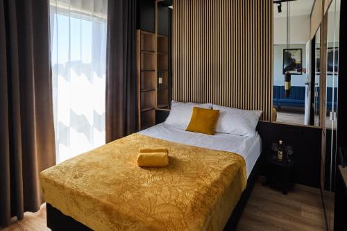 ジェシュフにあるApartament Niebieski Horyzont Kopisto 11 Centrum Miasta Rzeszówの黄色い毛布が掛けられたベッドのある寝室