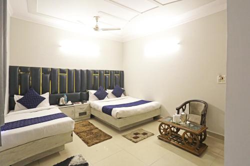 a bedroom with two beds and a table at Hotel Ratandeep at Paharganj in New Delhi