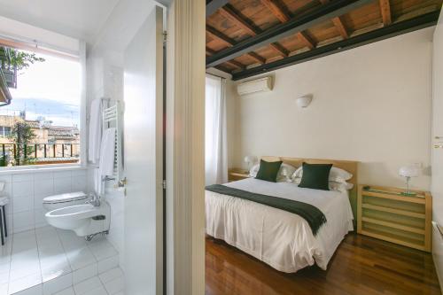 una camera da letto con un letto e un bagno con un lavandino di Rome Central Suite via Vittoria a Roma