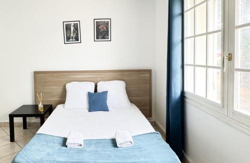 une chambre avec un lit avec une couverture bleue dans l'établissement Studio Platanes 5 - Proche Disneyland - Parking gratuit - Meaux, à Meaux