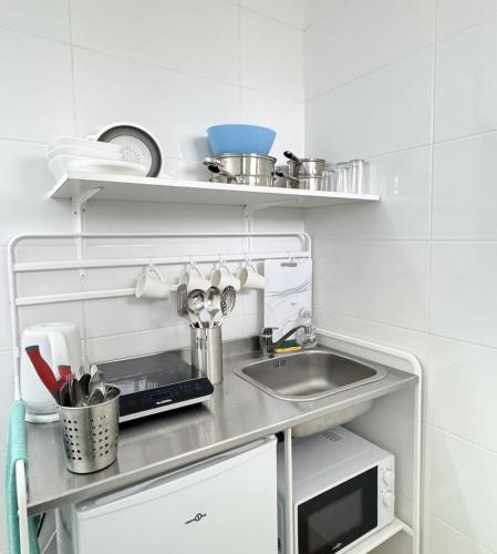 une cuisine avec un évier et un micro-ondes dans l'établissement Studio Platanes 5 - Proche Disneyland - Parking gratuit - Meaux, à Meaux