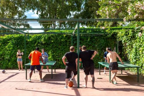 a group of men playing a game of ping pong at Fabulous village in Casal Palocco