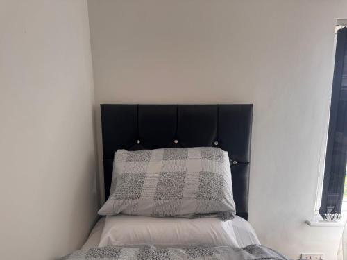 a bed with a black headboard and a pillow at Modern Nest in Nelson