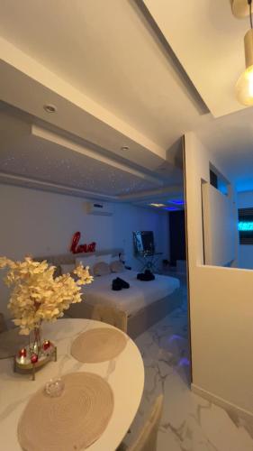 - un salon avec une table, un lit et une télévision dans l'établissement Trésor Étoile, luxe & lumière - Duplex 4 personnes, à Pertuis