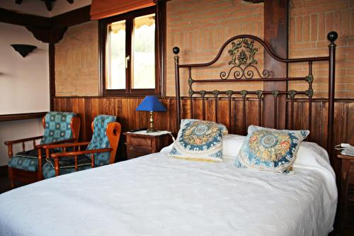 a bedroom with a large bed with two pillows at Casa de Aldea El Valle in Buelna