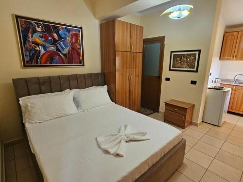 un dormitorio con una cama con un lazo encima en Villa Noar, en Vlorë