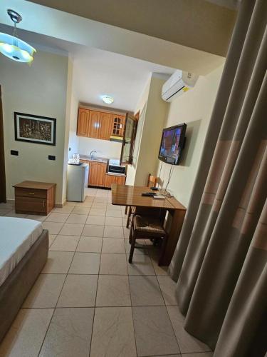 Un dormitorio con un escritorio con una computadora y una cocina. en Villa Noar, en Vlorë