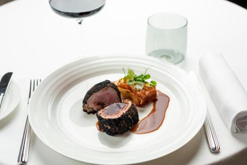 a white plate with some food on a table at Hilton Turin Centre in Turin