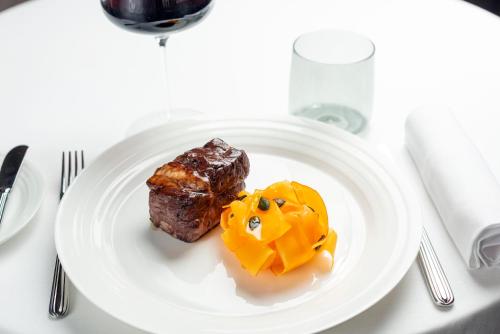 a white plate with some food on a table at Hilton Turin Centre in Turin