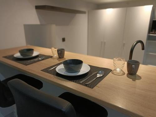 a wooden table with two cups and plates on it at Stijlvolle Designstudio in Almere