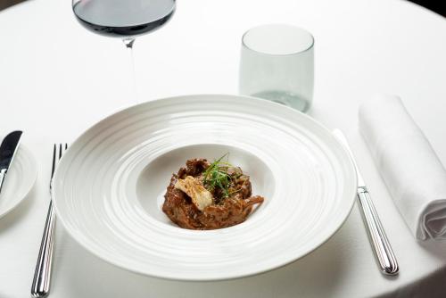 a white plate of food on a white table at Hilton Turin Centre in Turin