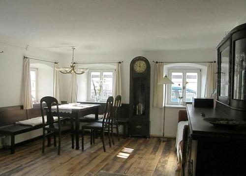 a dining room with a table and chairs and a clock at Ferienhaus in Schernfeld